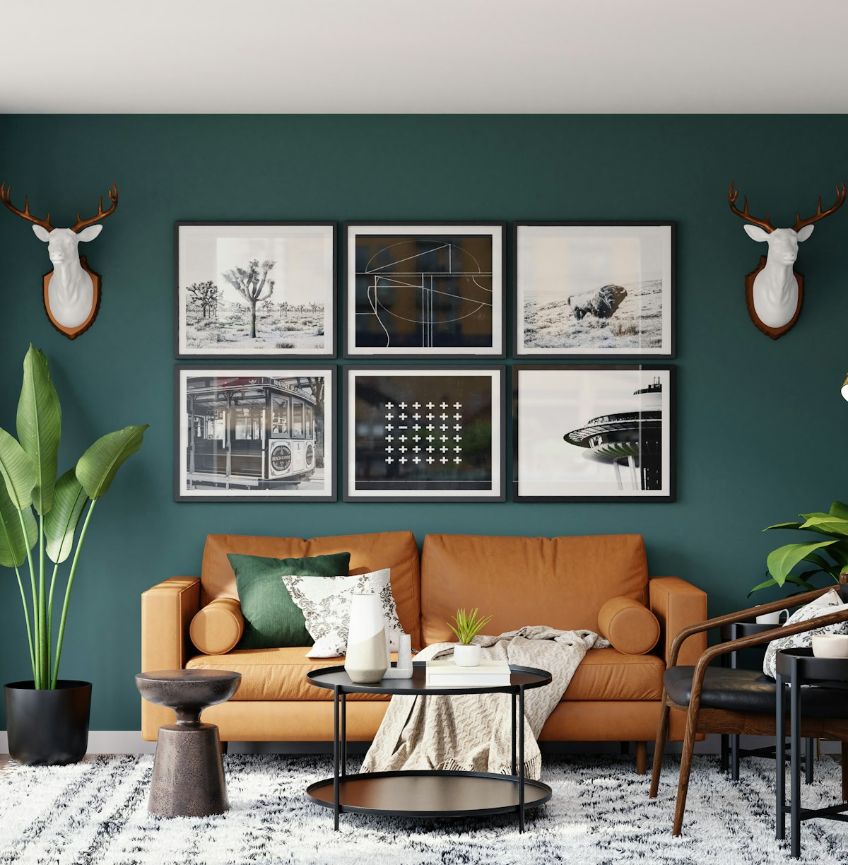 Living room with a deep green feature wall, framed gallery and a tan leather sofa
