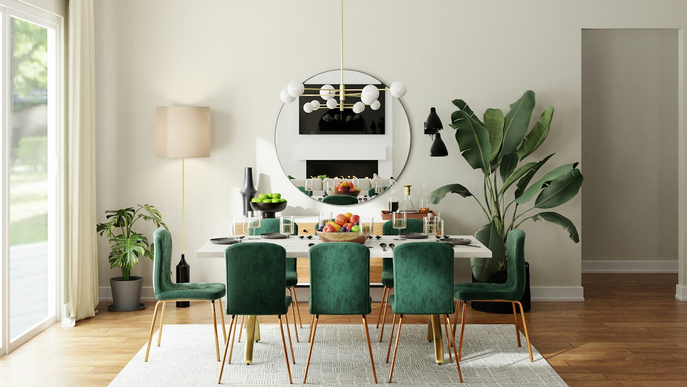 Dining room with green velvet chairs, a round mirror and pendant light