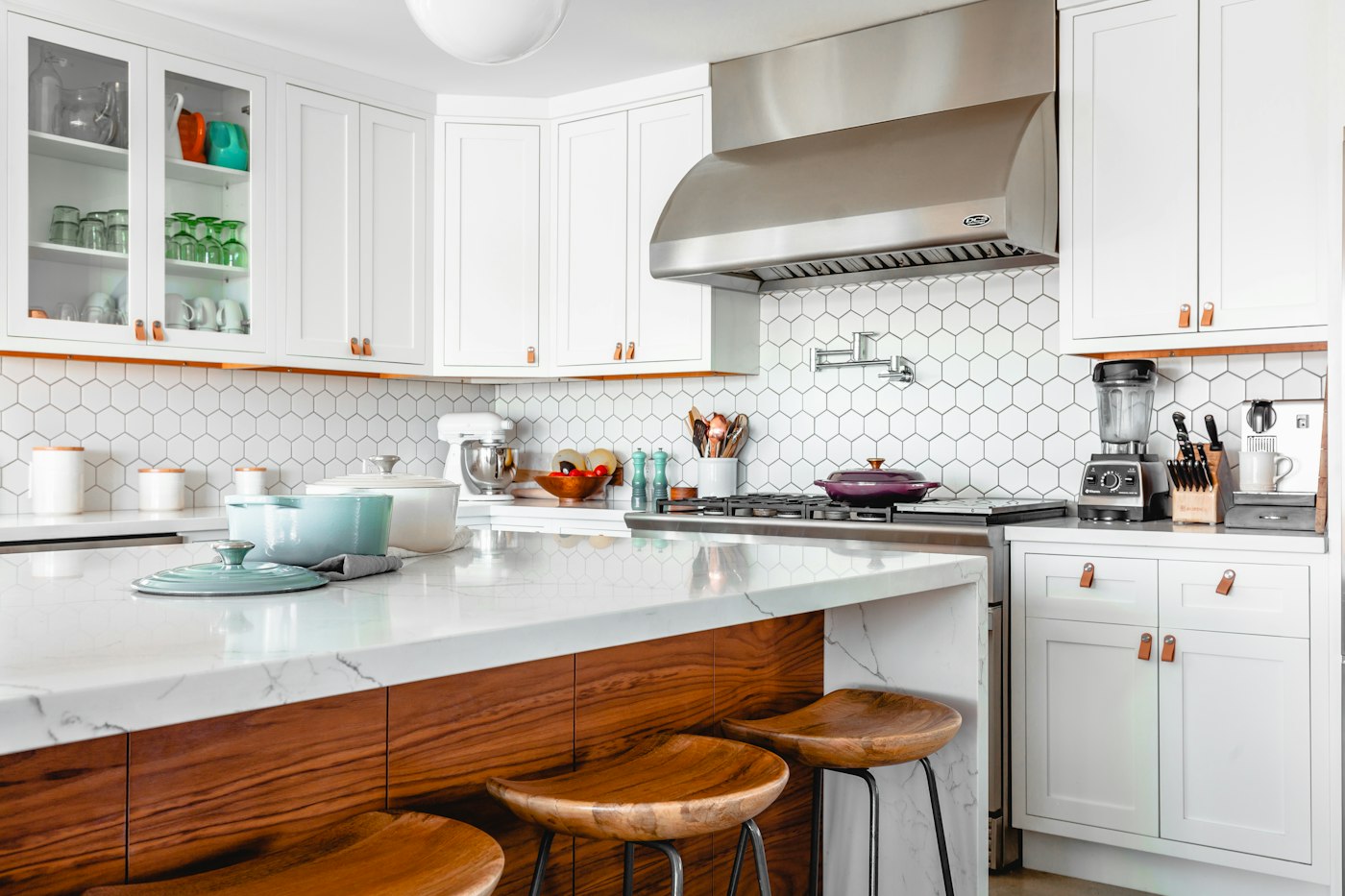Bright modular kitchen with white cabinets, stone counters and a wood island