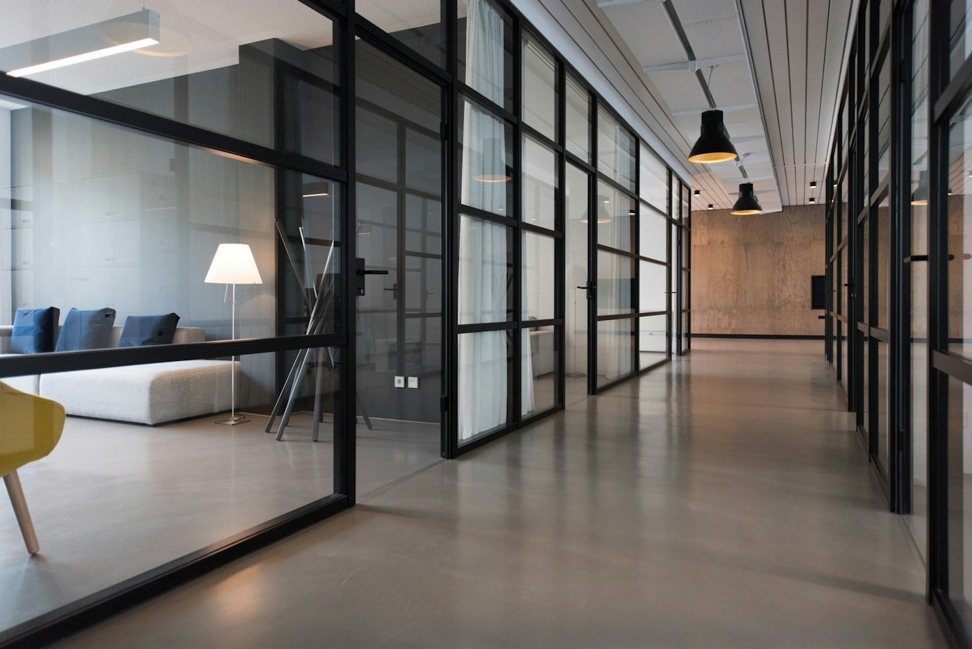 Modern office corridor with black-framed glass partitions